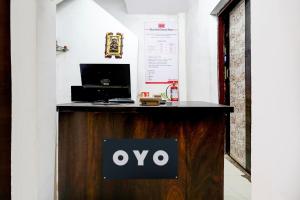 un bancone di legno con un cartello ovale sopra di Hotel O Deluxe United Corporate Home a Airoli