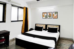 una camera da letto con un grande letto con lenzuola bianche e nere di Hotel O Deluxe United Corporate Home a Airoli