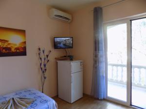 Habitación con nevera pequeña y ventana. en Apartments Las Cabezas, en Zadar