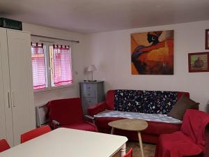 ein Wohnzimmer mit einem Sofa und roten Stühlen in der Unterkunft Studio central au Lioran avec terrasse et parking - FR-1-787-125 in Laveissière