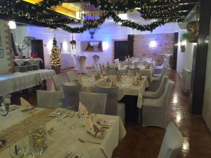 ein Restaurant mit weißen Tischen und Stühlen und einem Weihnachtsbaum in der Unterkunft Bliestal Hotel in Blieskastel