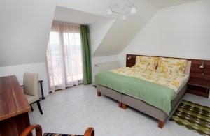 una camera con letto, scrivania e finestra di Szabó Ház a Hévíz