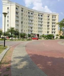 a large building with a red car parked in front of it at Radhika Residency At Omaxe Eternity in Vrindāvan