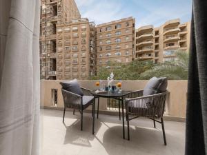 a balcony with a table and chairs and a building at Exclusive stay with luxury touches at 22 by spacey #55 Studio in Maadi in Cairo