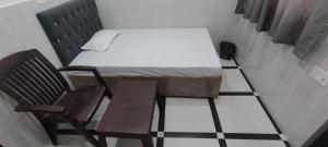 a small room with a bed and a chair at Hotel samriddhi palace in Gonda