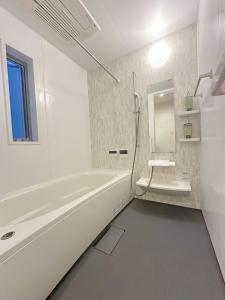 a white bathroom with a tub and a sink at 全新房源 一線直達夢洲站 明泰ハウス Mighty Lodge in Osaka +19 photos