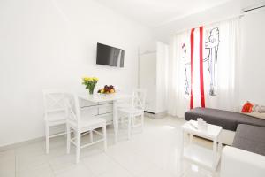 a white living room with a table and a couch at Apartment LU in Split