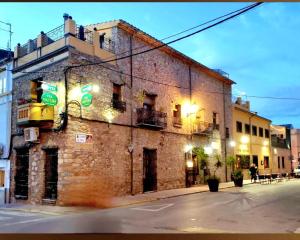 an old brick building on a city street at night at Vía Natura Hotel Rural in Cabanes