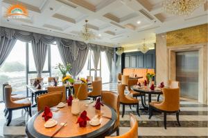 a restaurant with tables and chairs and a large window at Khách sạn Solis Hotel in Hai Phong