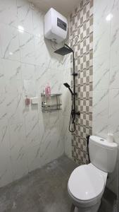 Un baño con un inodoro blanco y una pared. en Omah Gedongan Homestay, en Sawahan 6 fotos más