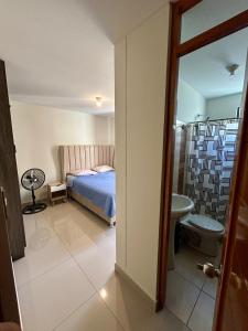une chambre avec un lit et une salle de bain avec WC dans l'établissement Departamento en edificio de estreno en Chiclayo, à La Victoria
