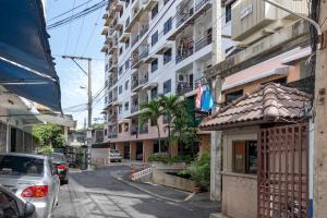 a city street with cars parked in front of buildings at Thip Residence at Surawong in Bang Rak