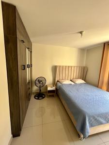 - une chambre avec un lit et un bureau avec un ventilateur dans l'établissement Departamento en edificio de estreno en Chiclayo, à La Victoria