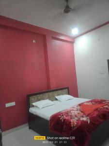1 dormitorio con paredes rojas y 1 cama. en Kishan guest house, en Ayodhya