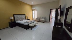 San BenitoCasa Itza的卧室里有一张床和一把椅子