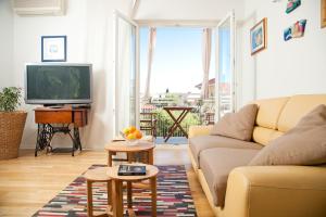 a living room with a couch and a tv at Apartment Roko in Split