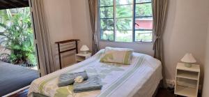 ein Schlafzimmer mit einem Bett, auf dem ein Stofftier liegt in der Unterkunft Coconut Cottage Christmas Island in Flying Fish Cove