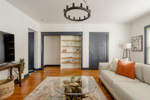 un soggiorno con divano bianco e tavolo in vetro di Stay Portland - Spacious Restored Craftsmen - Craft Beer & Coffee a Portland