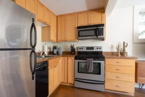 a kitchen with a refrigerator and a stove top oven at Stay Portland - Joshua Tree Vibes in SE PDX - Local Bars & Food in Portland