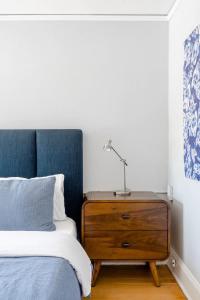 ein Schlafzimmer mit einem Bett und einer Kommode mit einer Lampe darauf in der Unterkunft Stay Portland - Classic 1920s Alberta Four Bedroom Haven in Portland