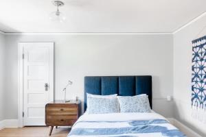 Bett mit blauem Kopfteil in einem Schlafzimmer in der Unterkunft Stay Portland - Classic 1920s Alberta Four Bedroom Haven in Portland + 25 Fotos