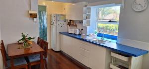 eine Küche mit einer blauen Arbeitsplatte und einem Tisch in der Unterkunft Coconut Cottage Christmas Island in Flying Fish Cove