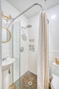 un bagno bianco con doccia e lavandino di Stay Portland - 1910 Historic Jessie Morehead House - 98 WalkScore a Portland