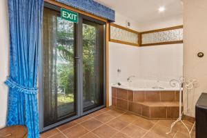 丹德农山StayAU Bayview Candlewick Suite SPA in Dandenong的带浴缸和大窗户的浴室