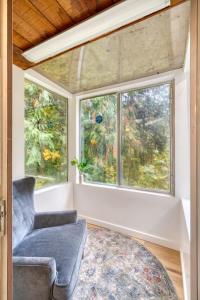 a living room with a chair and a window at Stay Portland - Sandy Riverfront Mt Hood Cabin! 9 Queen Beds! in Rhododendron