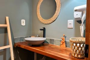 uma casa de banho com um lavatório num balcão de madeira em Casa Brisa do Vale - Lençóis - BA em Lençóis