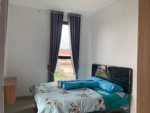 巴图Athara Villas的窗户间内的一张带蓝色枕头的床