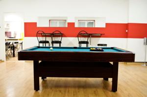 a pool table in a room with three chairs at Nitra Glycerin Hostel in Nitra