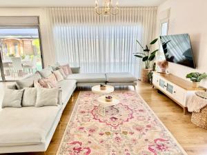 Gid‘onaשלווה בגלבוע - וילה מהממת עם ג'קוזי ובריכה בגדעונה的客厅里有一张沙发和一台电视