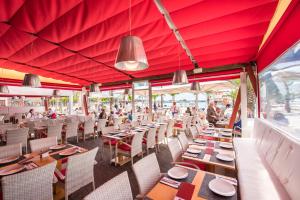 um restaurante com tecto vermelho e mesas e cadeiras em Hostal Brisa Marina em Port d'Alcudia