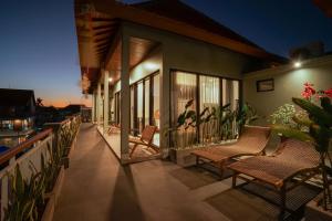 a balcony of a house with chairs and plants at Navee Studio Apartments Canggu in Munggu