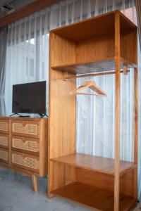 a wooden entertainment center with a television and a desk at Navee Studio Apartments Canggu in Munggu