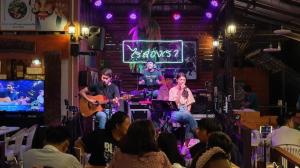 eine Gruppe von Personen in einem Raum mit einer Band auf der Bühne in der Unterkunft Raisongrao Resort Khao Kho in Ban Huai Phai