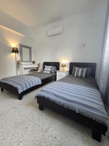 a bedroom with two beds and a table at SunNsea Apartment in Paphos +30 photos