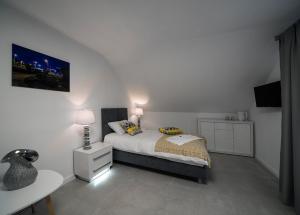 a white bedroom with a bed and a night stand at KP Claudia in Wieliczka
