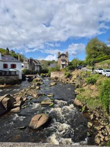 a river with rocks and houses in a town at Mobil home 3 chambres tout équipé avec accueil humain in Pont-Aven