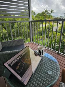 a book and a cup of coffee on a table on a balcony at Kallangur 3 Bedroom Townhouse in Kallangur