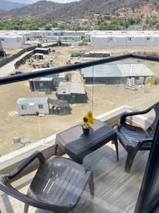 a balcony with a table and chairs and a view of a building at Tamarielys 1BR Vista a la montaña in Rodadero