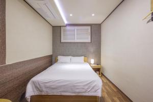 a small room with a bed and a window at LEBROWN Stay in Seoul