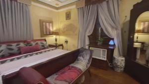 una camera con un letto, un divano e una finestra di Amelia Suite - Barbara a Manila
