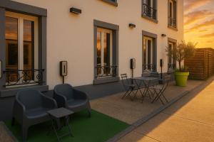 ein Gebäude mit Stühlen und Tischen auf einer Terrasse in der Unterkunft Logis Hôtel du Cirque Troyes centre historique in Troyes