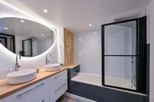 ein Badezimmer mit zwei Waschbecken und einem großen Spiegel in der Unterkunft La Cormorane - 100m plage - Parking in La Plaine-sur-Mer