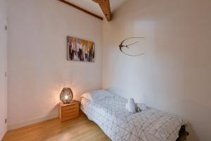 ein Schlafzimmer mit einem Bett und einer Lampe in der Unterkunft La Cormorane - 100m plage - Parking in La Plaine-sur-Mer