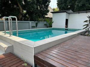 a swimming pool with a wooden deck and a swimming poolvisor at OHDEE Hostel Chiangmai in Chiang Mai