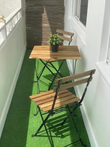 ein Tisch und eine Bank auf einer Veranda mit einer Topfpflanze in der Unterkunft Amancay in Cedeira