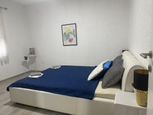 a bedroom with a bed with a blue blanket at Holiday House As Moon in Mostar